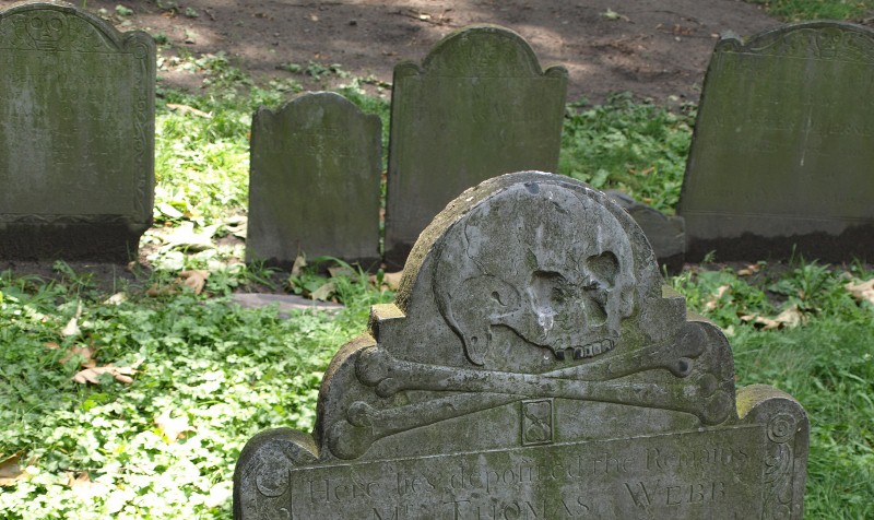 A skull and cross bones carved into an old tombstone
